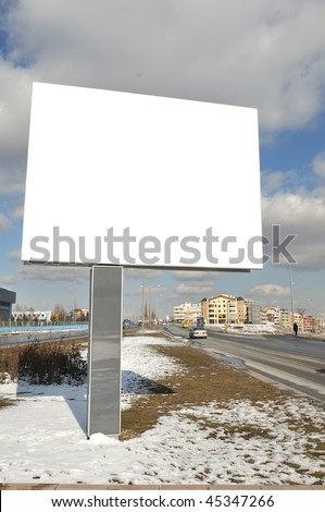 Outdoor advertisement with big blank billboard over cloudy sky. Put your own text here