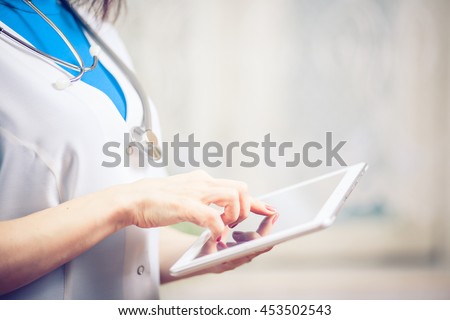 Woman doctor using tablet computer in hospital