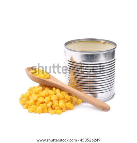 Tincan with a pile of canned corn and a wooden spoon next to it, composition isolated over the white background