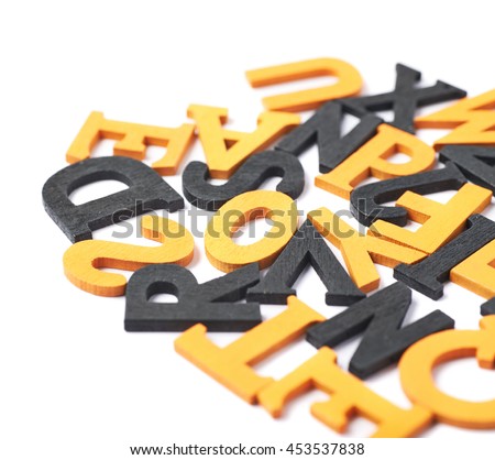 White surface covered with the multiple colorful black and orange painted wooden letters as a Halloween backdrop composition