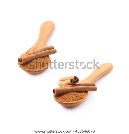 Wooden spoon full of cinnamon powder and raw bark sticks on top of it, composition isolated over the white background, set of two different foreshortenings