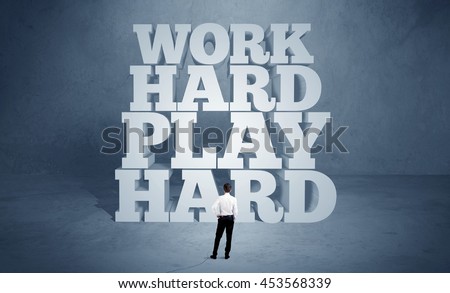 A confident salesman in suit standing in front of illustrated block letters saying work hard play hard concept