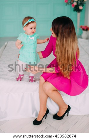 Mother and baby closeup portrait, happy faces, european family picture, adorable small girl, mom and kid having fun indoor, holding little child, healthy toddler and mommy, happiness concept