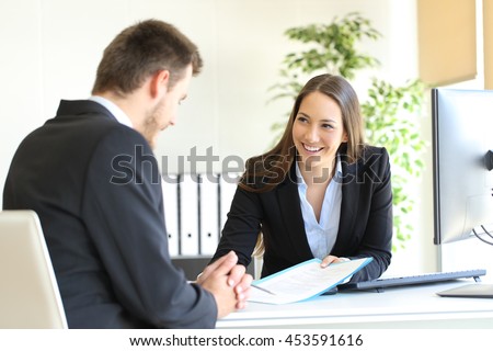 Dealer attending to a customer in a desktop in the office Royalty-Free Stock Photo #453591616