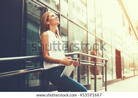 Young woman listening to music on the digital tablet