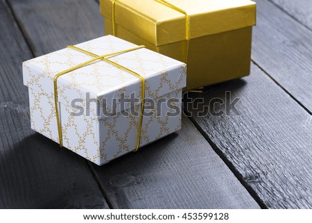 white and golden gift boxes  on black wooden table background