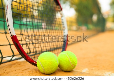 Tennis Ball and Racket on clay court