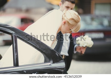 The brides hold hands near car