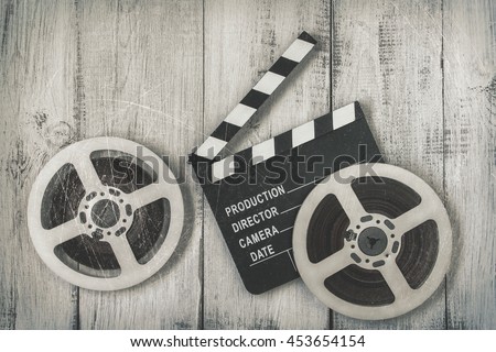 Clapperboards and two reels of film.Black and white stylized photo
