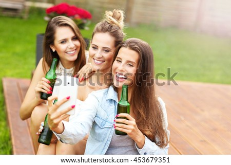 Picture presenting happy group of friends having a beer outdoors