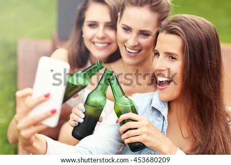 Picture presenting happy group of friends having a beer outdoors