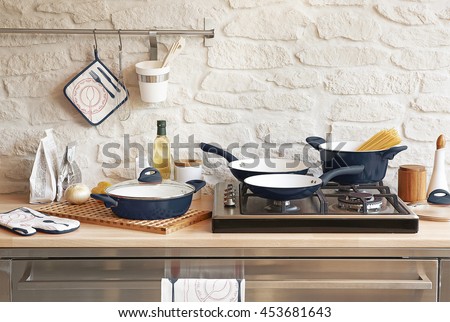 modern red kitchen behind brick wall with red cookware set Royalty-Free Stock Photo #453681643