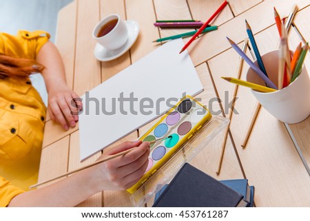 Young school gilr drawing pictures at home