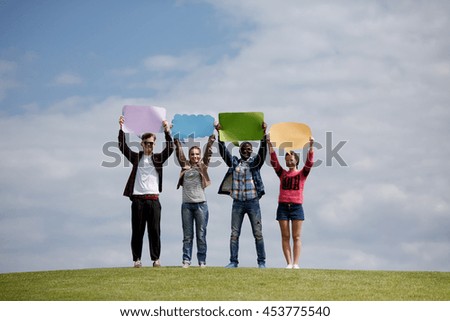 Picture of best friends holding papers with space for any ideas on picnic. Happy people in full length isolated on blue sky.