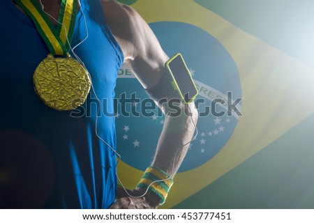 Brazilian gold medal athlete standing with mobile phone armband and headphones against dramatically lit Brazil flag background with lens flare