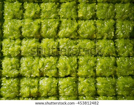 Staff drop topping on Sweet Green  sticky rice before sell to shop and people for eat . It thai dessert.in the factory on business.