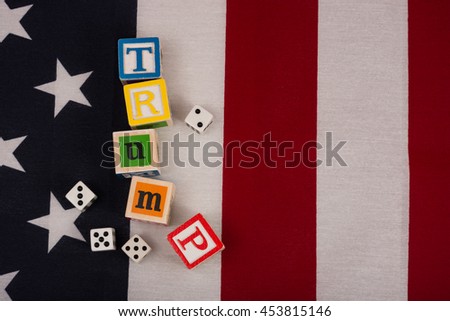 Gamble on Trump.  Trump spelled out with children's blocks on top of an American flag with two pairs of dice.  