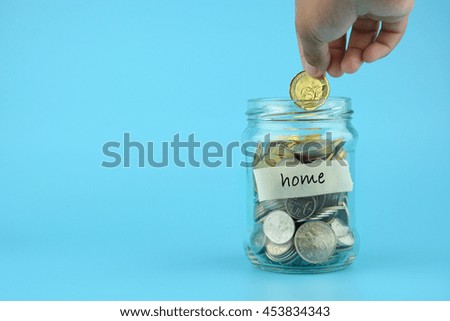 Hand's women putting coin in money jar with text on navy blue background. Concept of investments, insurance, savings plans.