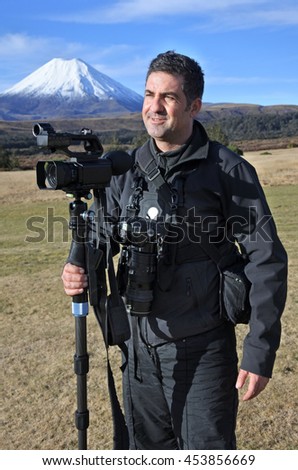 Professional travel videographer and photographer photographing Mount Ngauruhoe outdoors during on location photo assignment in Tongariro National Park New Zealand. Copy space.