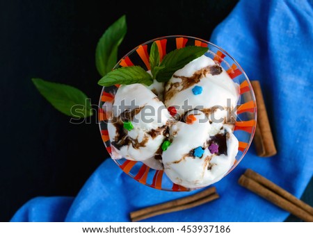 Ice cream, decorated with chocolate syrup and mint in a glass. top view