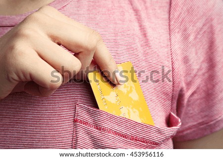 Female hand putting credit card in pocket