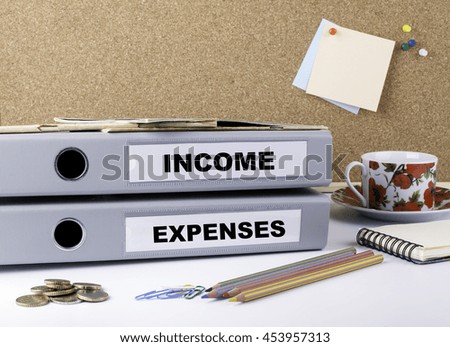 Income and Expenses - two folders on white office desk
