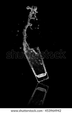 Water splash out of glass on a black background.