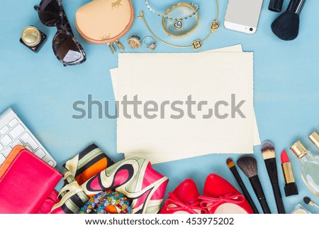 styled feminine desktop - woman fashion items on blue wooden background with aged blank paper notes