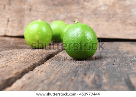 lemon with green closeup Select focus with shallow depth of field on the wooden