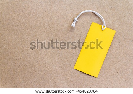 Empty yellow price tag on brown paper background