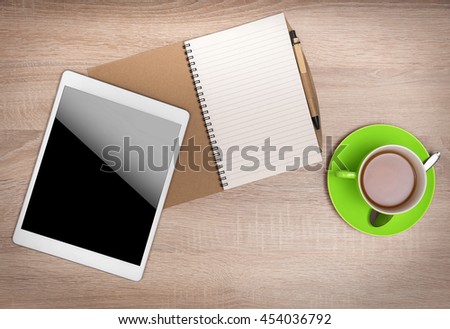 Tablet PC, notebook and cup of tea on the desktop. Top view.