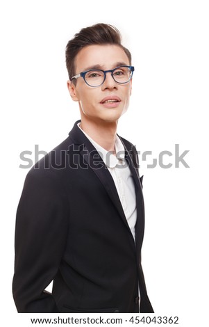 Young stylish man isolated at white. Portrait of confident guy looking at camera. Boy style, trendy male person in eyeglasses and black suit. Modern businessman.