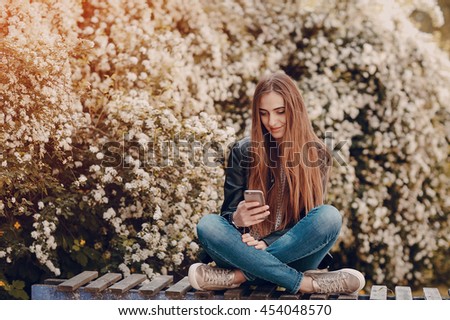 beautiful girl on the street using cell phones, a tablet and walks