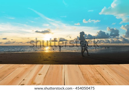 Look out from the table, blur image of happy family at sunset on the beach in Phuket, Thailand as background.