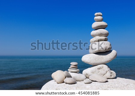 Balance and poise stones against the sea. White Rock zen on the background of blue sky