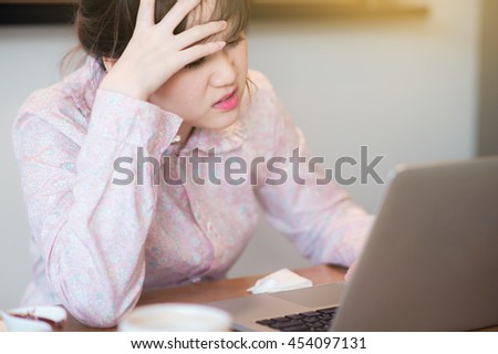 Women who are  stress and pressure on business while sitting at the laptop in a cafe .