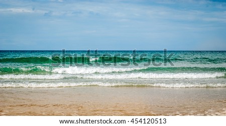 Tropical sandy beach with clear sky at the low tide. Atlantic ocean Spain. Blue skies, clouds over tropical beach with sand in Mediterranean, Tropic or Atlantic sea in Spain, Croatia, Italy or Greece.