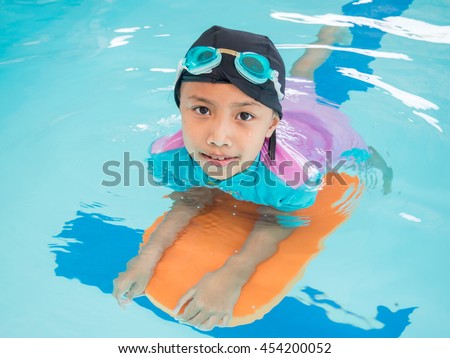 Little asian kids girl in swimming pool. Summer outdoor.