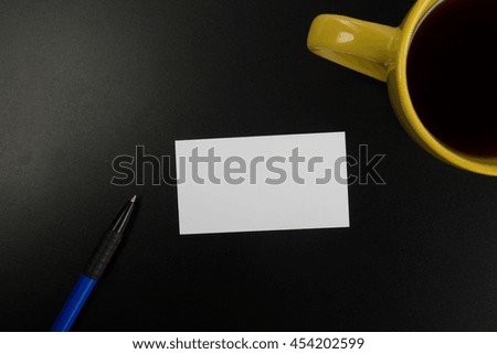 Office table desk with supplies white blank business visit card, gift, ticket, pass, present close up on black background. Copy space Blank corporate identity package business card Template for ID. 