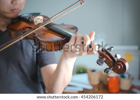 man playing violin close up and selective focus image , (vintage color effect)
