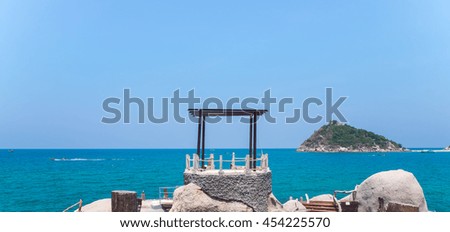 Ocean Front Dock Ship Yard with Rock White Beach and Separate Tropical Island View. Green Sea and Blue Sky. Koh Tao and Koh Nang Yuan Thailand