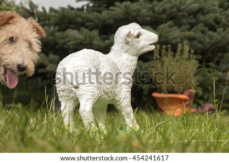 White ceramic plaster statuette of a lamb, sheep on the grass.