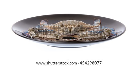raw crab on a black plate isolated on white background.