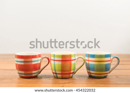 Beautiful and colorful three coffee cup on wooden table with copy space for text.