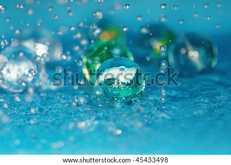 Extremely close-up macro photo of the glassy balls in the water. Shallow depth of field for natural view
