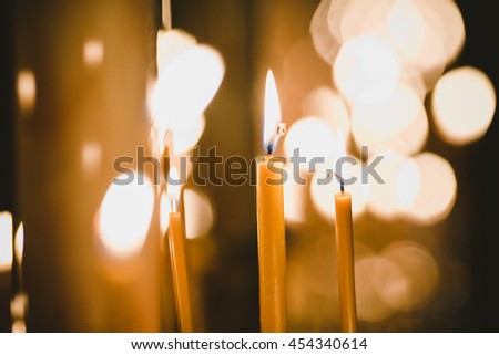 A blurred picture of burning thin yellow candles