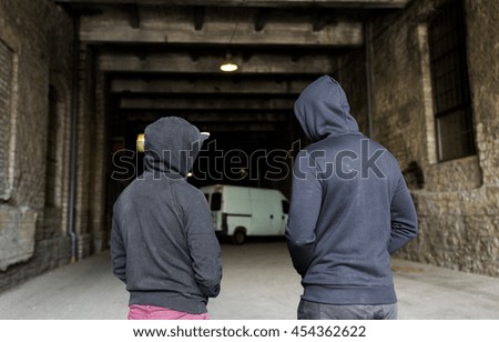 criminal activity, addiction, people and social problem concept - close up of addict men or criminals in hoodies on street Royalty-Free Stock Photo #454362622