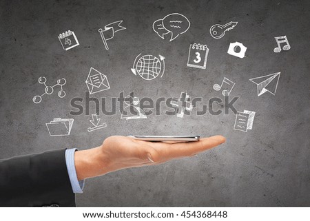 people, technology and communication - close up of hand with smartphone and media doodles over gray concrete background