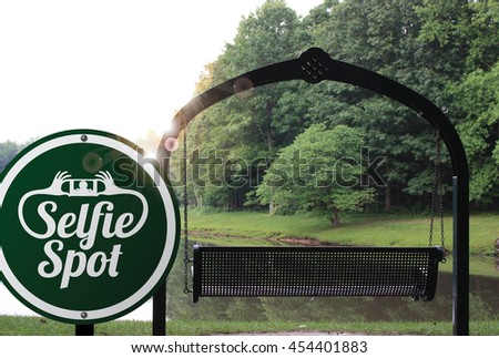 Selfie spot sign near a romantic swing for two. Concept of taking a self portrait in a scenic spot.