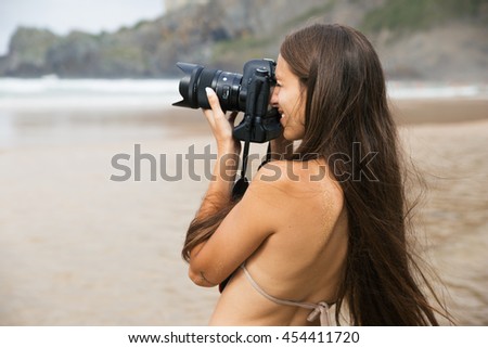 Girl taking photos in the beach and smiling